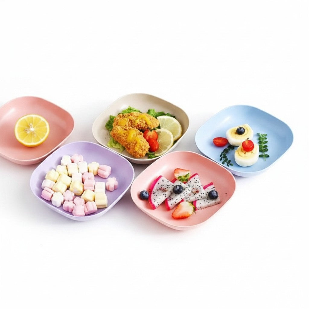 Kit de pratos reutilizáveis Cucinamup em cores pastéis com petiscos, frutas e sobremesas dispostos sobre a mesa.